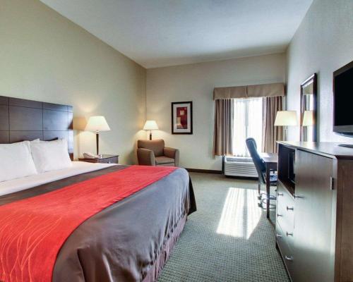 莫斯波因特Comfort Inn Moss Point Pascagoula的酒店客房设有一张大床和一张书桌。