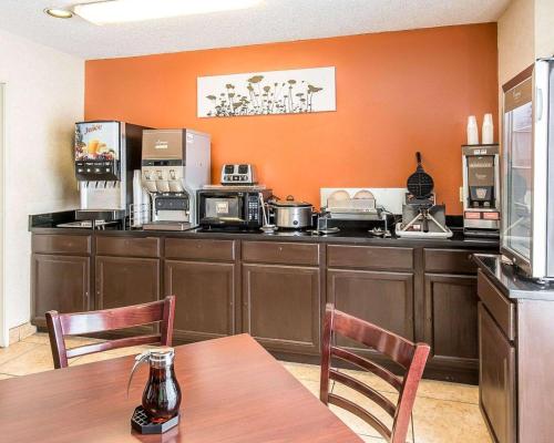 比林斯比林斯司丽普酒店的厨房拥有橙色的墙壁和桌椅