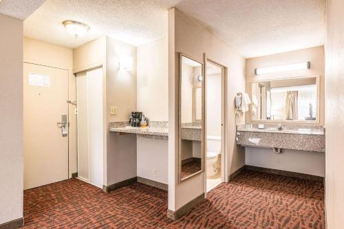 科尼利厄斯Lake Norman Inn and Suites的一间带水槽和镜子的酒店浴室