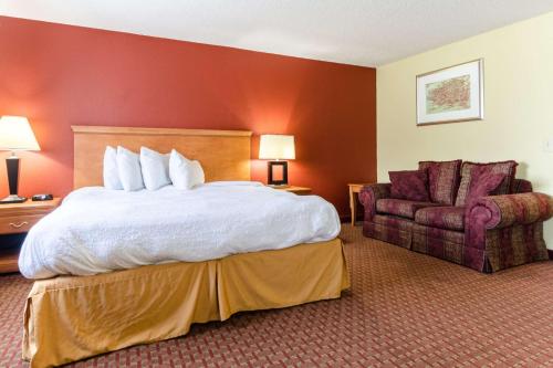 杰克逊维尔Rodeway Inn & Suites Jacksonville near Camp Lejeune的配有一张床和一把椅子的酒店客房
