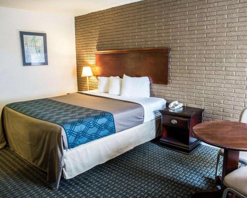 威尔明顿Rodeway Inn & Suites Wilmington North的酒店客房设有一张大床和一张桌子。