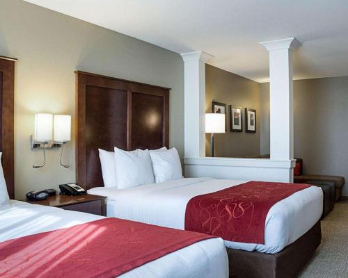 法戈Comfort Suites Medical Center的酒店客房,配有两张带红色床单的床