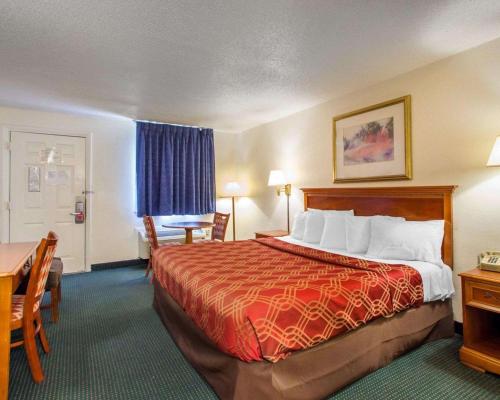 萨默斯波因特萨默斯珀恩特伊克诺旅店的酒店客房带一张床、一张桌子和椅子