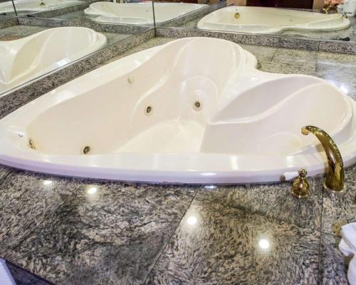 泽西市Rodeway Inn的大理石台面上的浴缸,配有水龙头