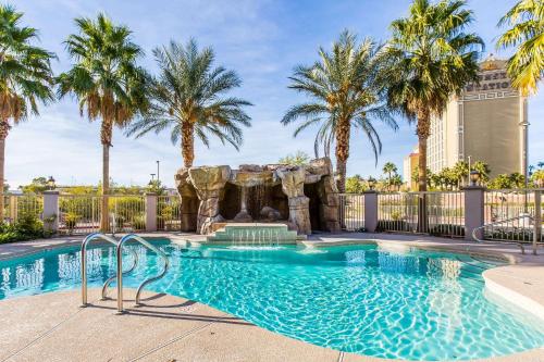 拉斯维加斯Comfort Inn & Suites Henderson - Las Vegas的一个带瀑布和棕榈树的游泳池