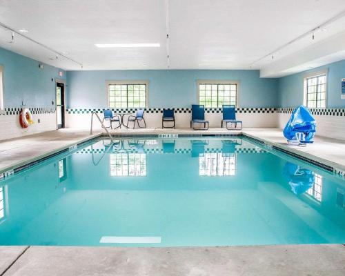 汉堡汉堡康福特茵套房酒店的一个带椅子和蓝色墙壁的游泳池