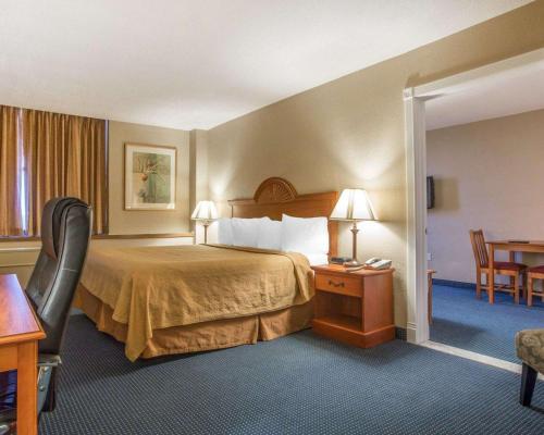 马塞纳Quality Inn Massena的酒店客房带一张床、一张桌子和椅子