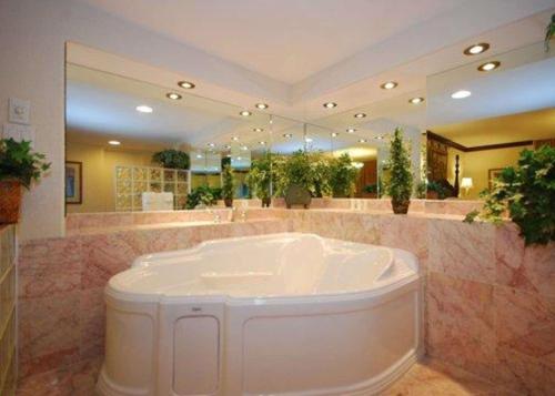 马塞纳Quality Inn Massena的带浴缸和大镜子的大浴室