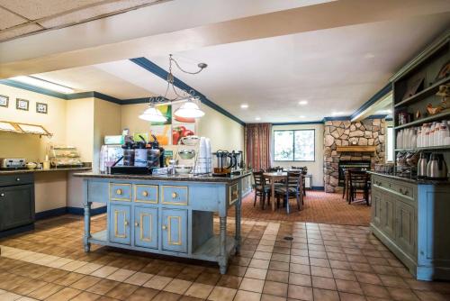 科特兰Quality Inn University Area的一间设有蓝色橱柜的厨房和一间用餐室