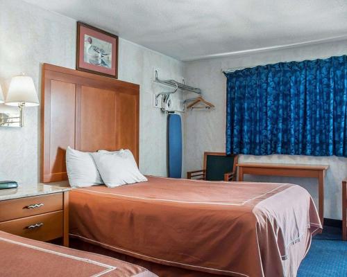 尼亚加拉瀑布Castle Inn & Suites Niagara Falls的酒店客房,配有床和蓝色窗帘