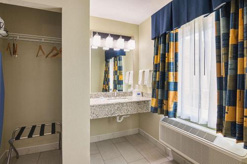 伊萨卡伊萨卡罗德威旅馆及套房的一间带水槽和镜子的浴室