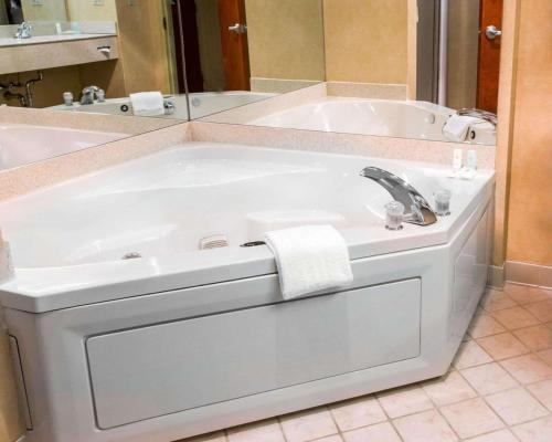 HawthorneComfort Inn & Suites Hawthorne的白色浴缸、水槽和镜子