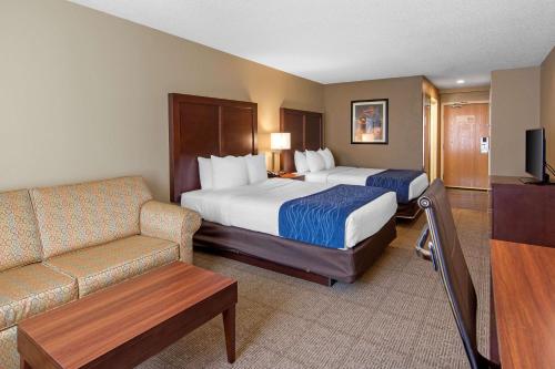 库珀斯敦Comfort Inn & Suites Milford - Cooperstown的酒店客房,设有两张床和一张沙发