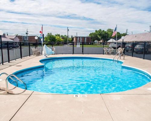 尼亚加拉瀑布Castle Inn & Suites Niagara Falls的一个带椅子和围栏的蓝色小游泳池