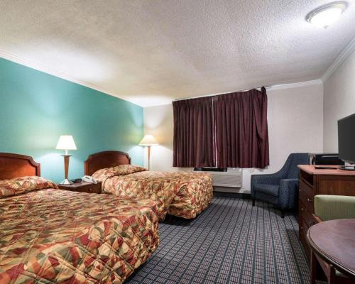 东叙拉古约翰米尔顿酒店的酒店客房设有两张床和电视。