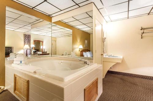 桑达斯基北罗德威酒店的大型浴室设有大浴缸和水槽