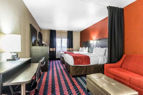 俄克拉何马城Comfort Suites Fairgrounds West的酒店客房,配有一张床和一张红色椅子