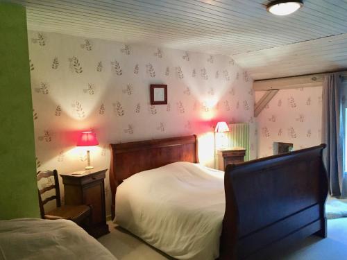 Les Rouges-Eaux奥尔博格夏洛特旅馆的一间卧室配有一张床、椅子和灯具