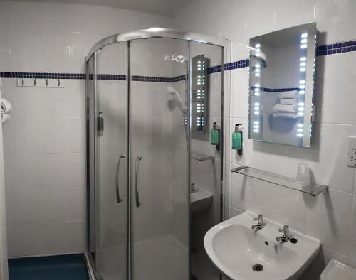 East StokeDorset Resort Hotel的带淋浴和盥洗盆的浴室