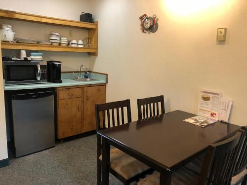 希利德纳里欧若拉汽车旅馆的厨房配有桌子、微波炉和桌椅。