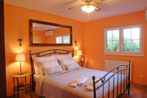 鲁巴达House 4 You的一间卧室设有橙色的墙壁和一张带镜子的床