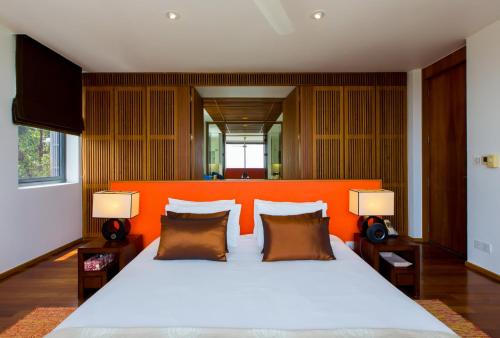 卡塔海滩The heights ocean views 2 bedrooms B15的一间卧室配有一张带橙色床头板的大床