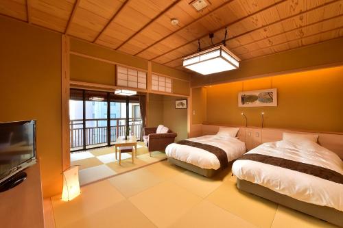 山之内町千寿阁酒店的一间带两张床和一台电视的卧室以及一个阳台