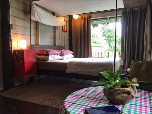 拜县班纳姆胡简易别墅旅馆的一间卧室配有一张床和一张带盆栽的桌子