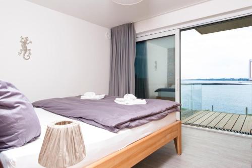 奥尔本尼兹Küstenküche的一间卧室配有一张床,享有水景