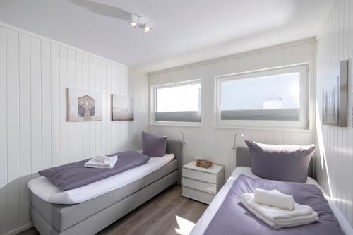 奥尔本尼兹Achtern Diek的一间卧室设有两张床和两个窗户。