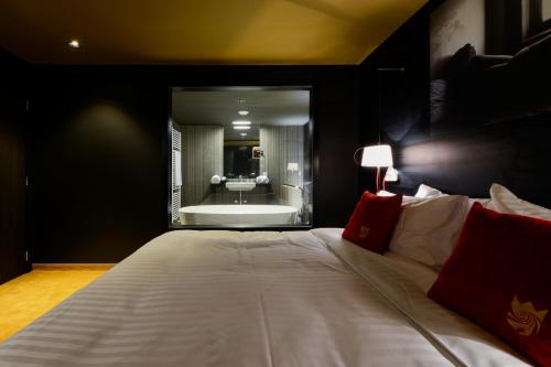 那慕尔皇家斯莱尔酒店的一间卧室设有一张大床和一个浴缸