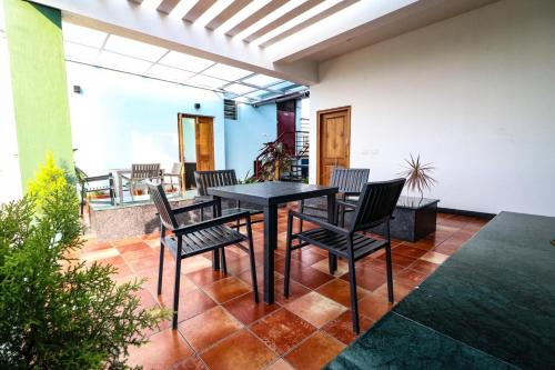 迈索尔Osho Glimpse Mysore的庭院配有黑色的桌子和椅子
