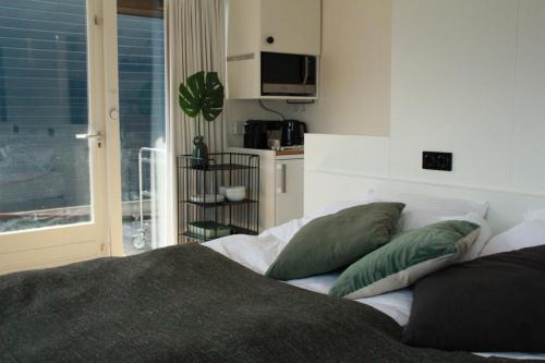 阿姆斯特丹Houseboat Studio Sooki的一间卧室配有一张带绿色枕头的床。
