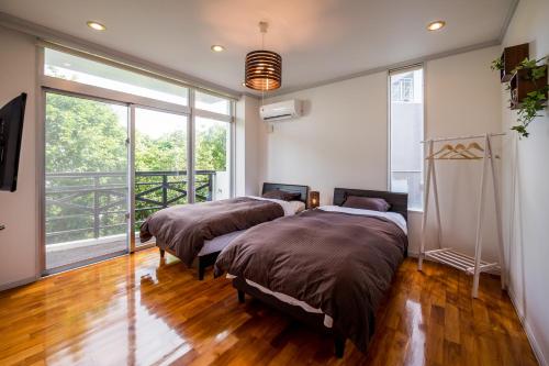 读谷村E-horizon Resort Condominium Yomitan的带大窗户的客房内的两张床