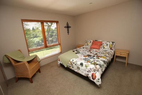 汉密尔顿On The River的卧室配有床、椅子和窗户。