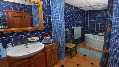 艾因西莱姆戈佐地中海景度假屋的蓝色瓷砖浴室设有水槽和浴缸