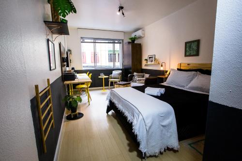 阿雷格里港Meu lugar na Cidade Baixa的一间卧室设有一张床和一间客厅。