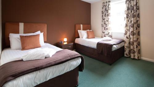 阿伯丁The Spires Serviced Apartments Aberdeen的酒店客房设有两张床和窗户。