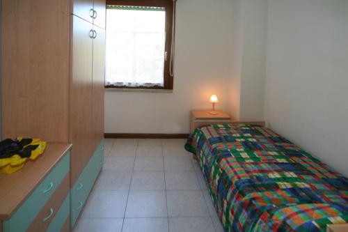 利尼亚诺萨比亚多罗Occidente的一间卧室配有一张床、一张书桌和一个窗户。