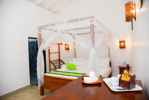 高尔Odailem Resort - Talpe的一间卧室配有一张带木桌的床