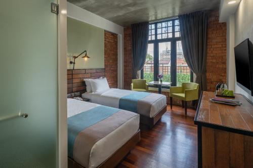 马六甲悦舍酒店的酒店客房设有两张床和电视。