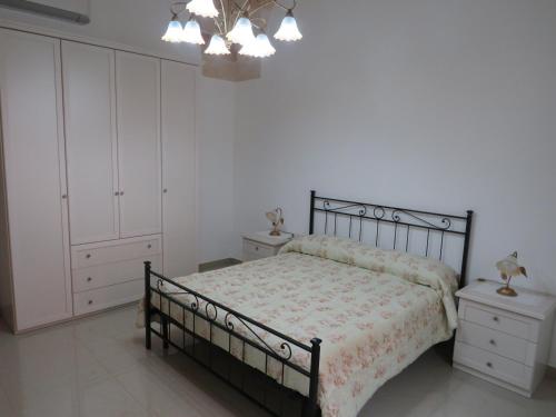 曼杜里亚Casa Rita的一间卧室配有一张床、白色橱柜和吊灯。