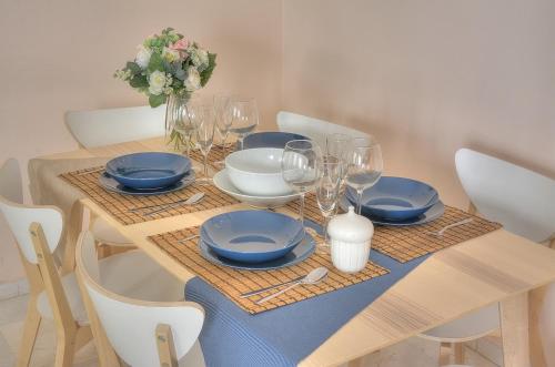 塞维利亚SEVILLA BUTTERFLY SUITES的一张带蓝盘和酒杯的木桌