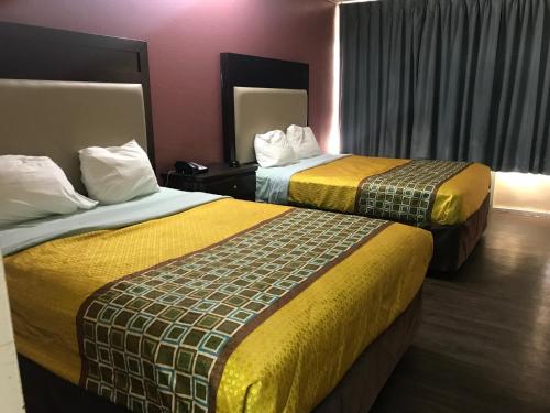 拉斐特Express Inn的酒店客房,配有两张带黄色毯子的床