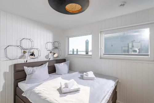 奥尔本尼兹Schwimmendes Haus 10 Grad Ost的一间卧室配有带白色床单和毛巾的床。
