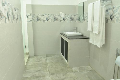 韦利格默Single Fin Weligama的白色的浴室设有水槽和镜子