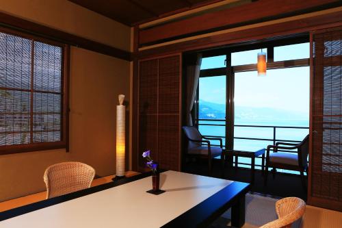 热海Taiseikan的客厅配有桌椅和窗户。