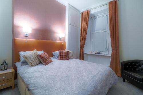 米尔盖West Highland Apartments Milngavie - The Nevis的卧室配有带枕头的床铺和窗户。