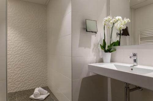 舍诺夫The Originals City, Hôtel Armony, Dijon Sud (Inter-Hotel)的白色的浴室设有水槽和镜子