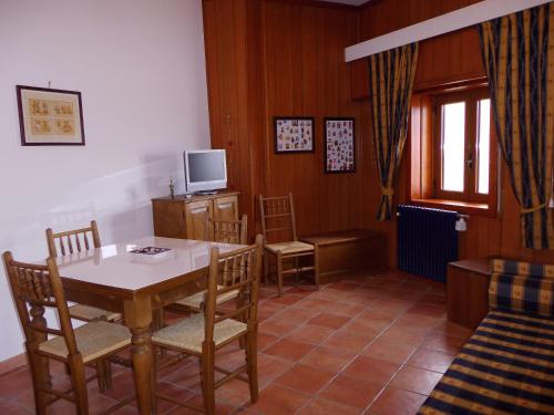 罗卡拉索Casa Dell'Orso的一间带桌椅和电视的用餐室